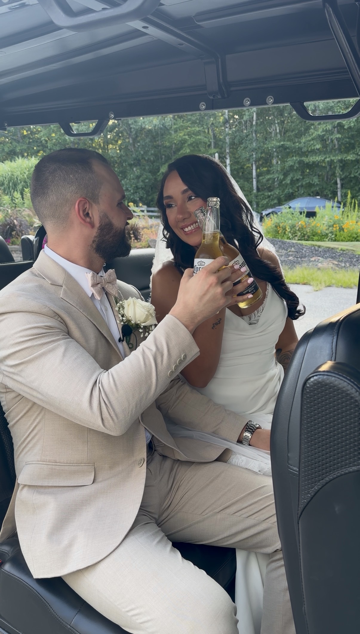 Yazmin & Nick toasting with Coronas in the back of a golf cart