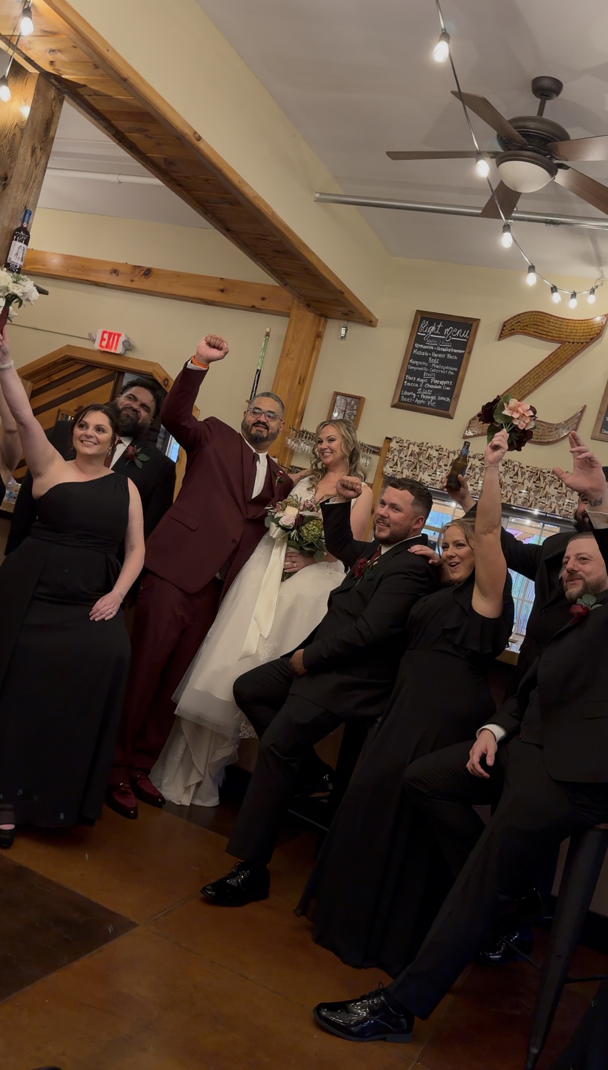 On the way back, the wedding party crowded into the tasting room with fists and bouquets in the air, under the chalkboard flight menu and the Zorvino Z made of wine corks.