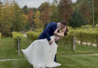 "Weekday vineyard wedding at Zorvino Vineyards: Andrew dips Courtney for a kiss between the vineyard rows as October foliage turns gold and red behind them"