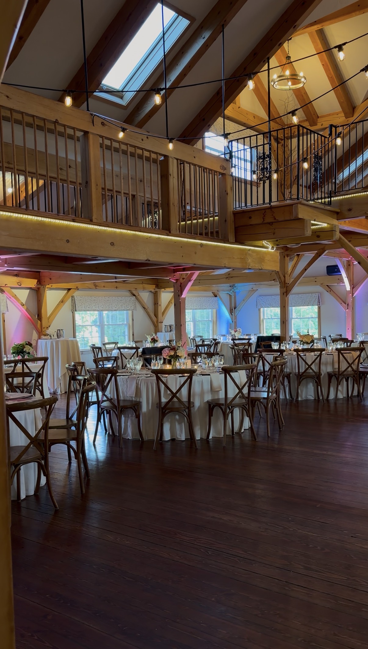 Tables with candlelight and string lights under the timber frame