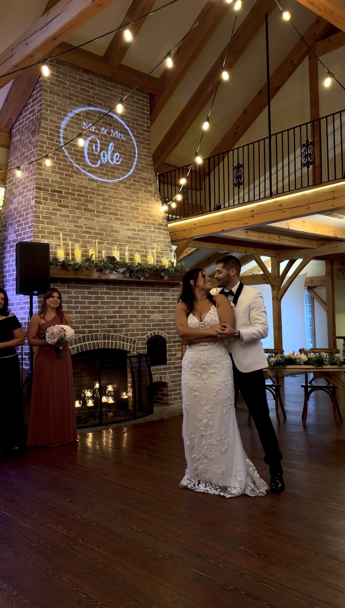 Bride and groom have their first dance in front of the fireplace.