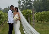 Bride and groom stand together in the vineyard.
