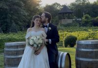 Bride and groom in front of the wine barrels.