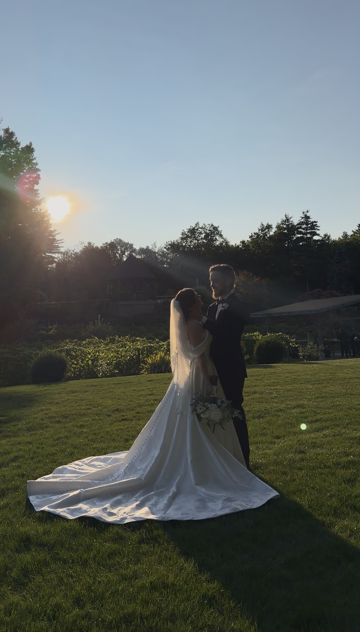 Bride and groom look into each other's eyes as the sun goes down.