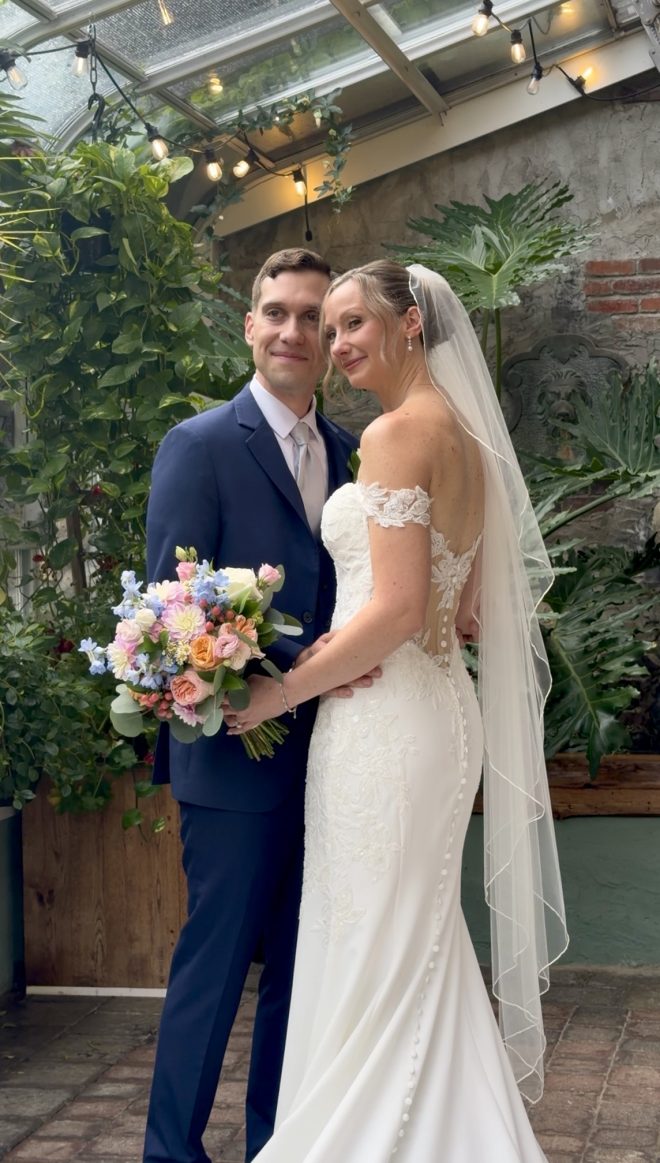 "Brittany Walters and Jesse Suhaka in the greenhouse conservatory at Zorvino Vineyards — summer wedding August 2026 Sandown NH"