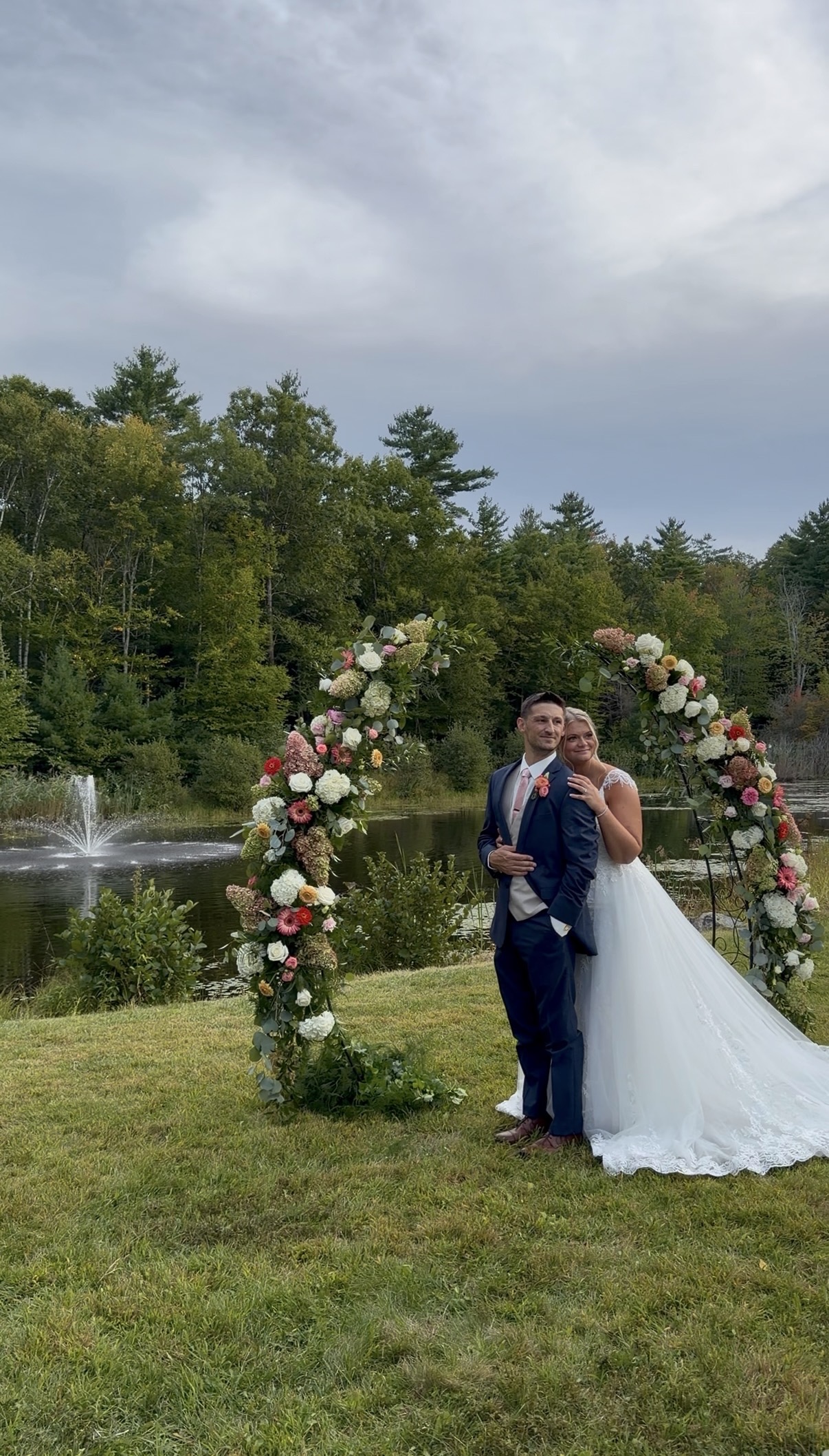 "Michael & Khyrstyne pictured between two floral arches at the pond”
