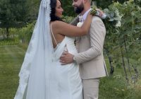 "Yazmin Rosa and Nick LaValley embracing among the vineyard rows at Zorvino Vineyards — Friday summer wedding July 2026 Sandown NH"