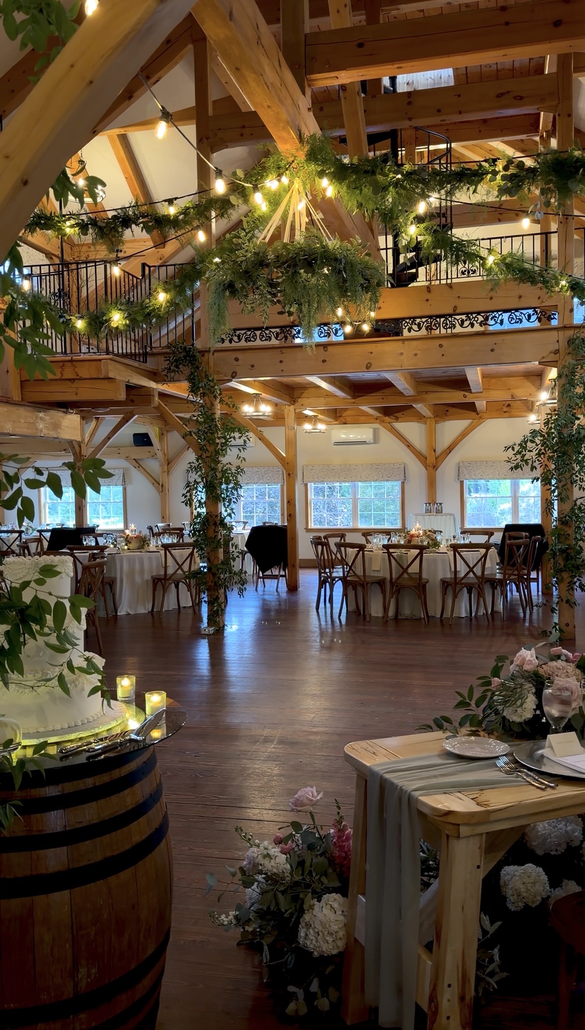 Zorvino's handcrafted post-and-beam venue, dressed in hanging greenery and warm string lights for the evening
