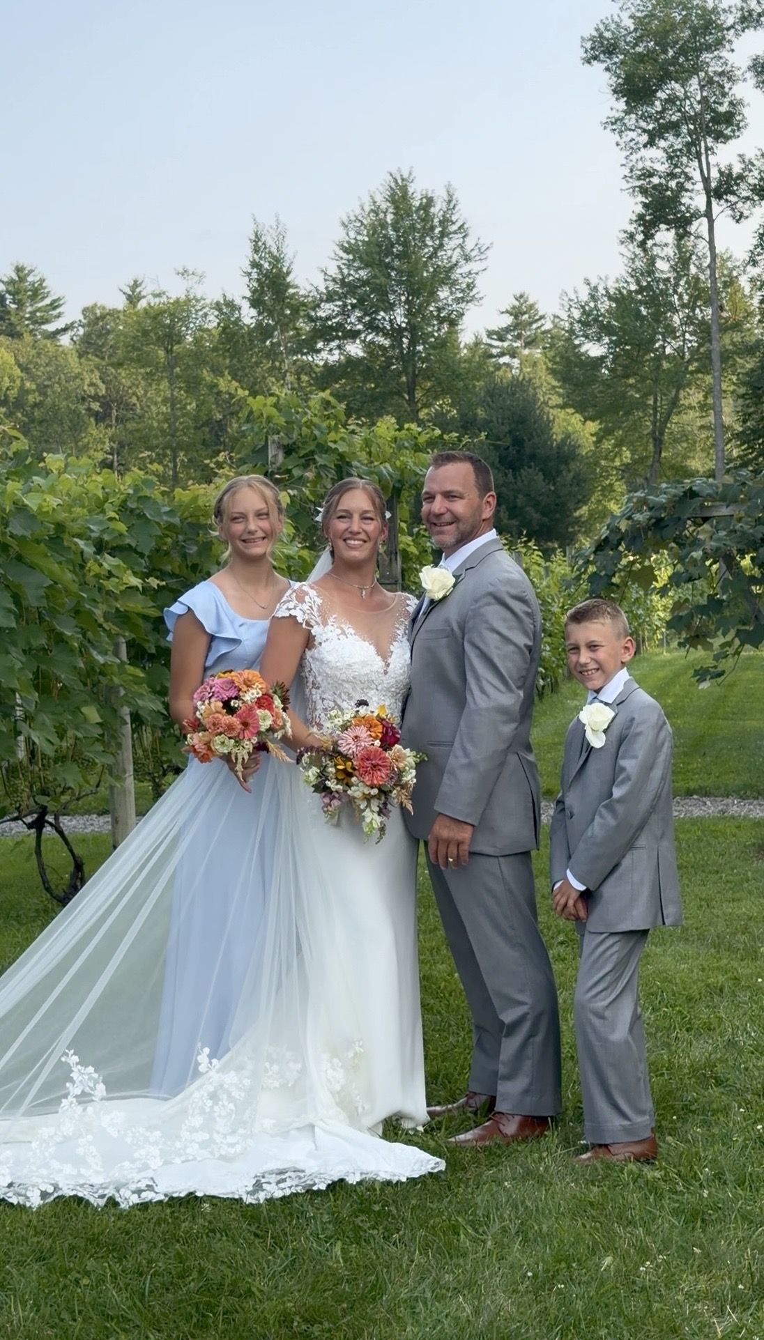 Elizabeth and Jeremy with their two children in the vineyard at their family vineyard wedding at Zorvino Vineyards