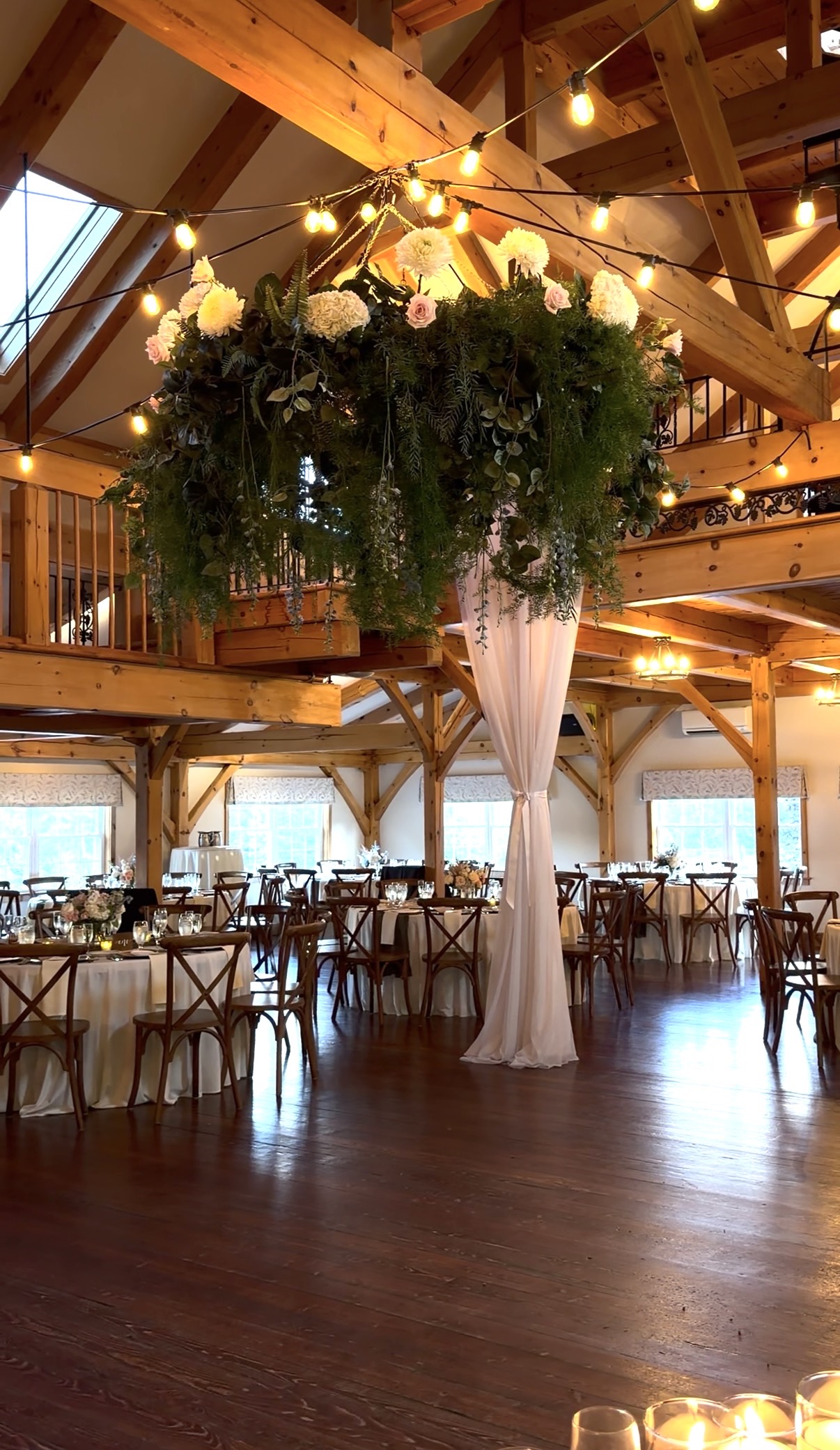 Suspended floral and greenery canopy over the reception at a summer garden vineyard wedding at Zorvino Vineyards