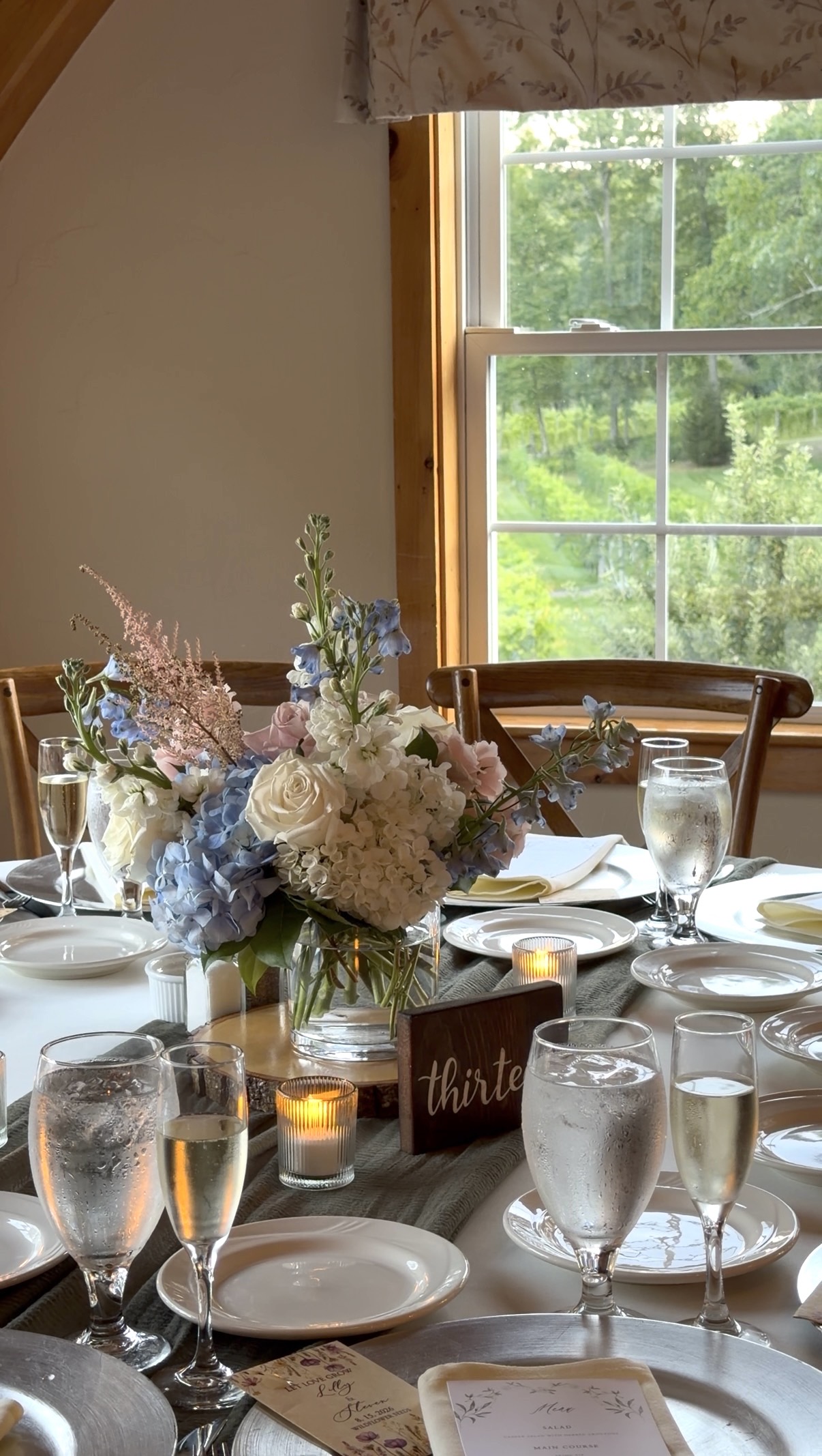 Blue, white, and blush centerpiece with hunter green runner at a summer garden vineyard wedding reception at Zorvino Vineyards