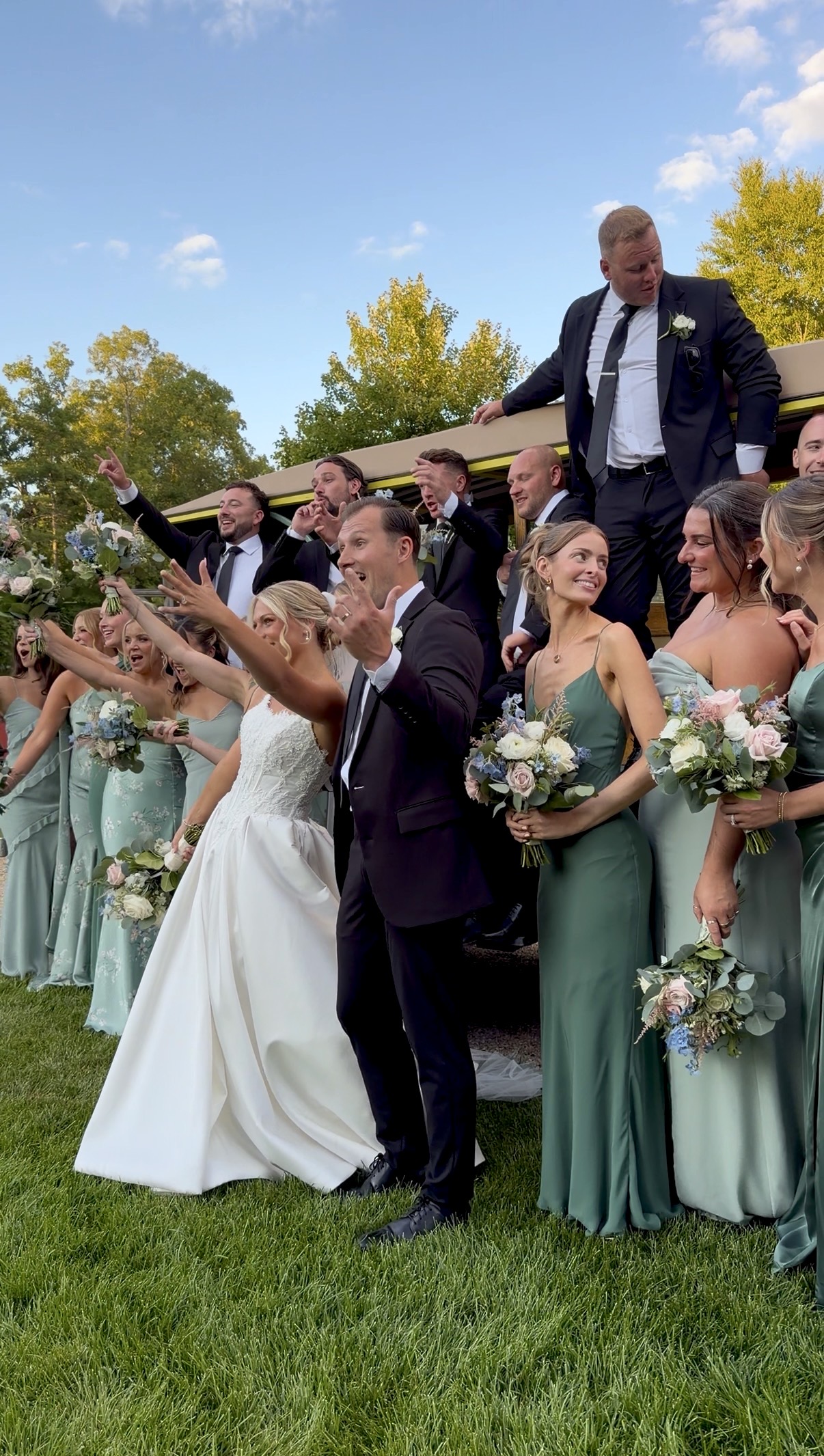 Wedding party in sage green celebrating at a summer garden vineyard wedding at Zorvino Vineyards in New Hampshire