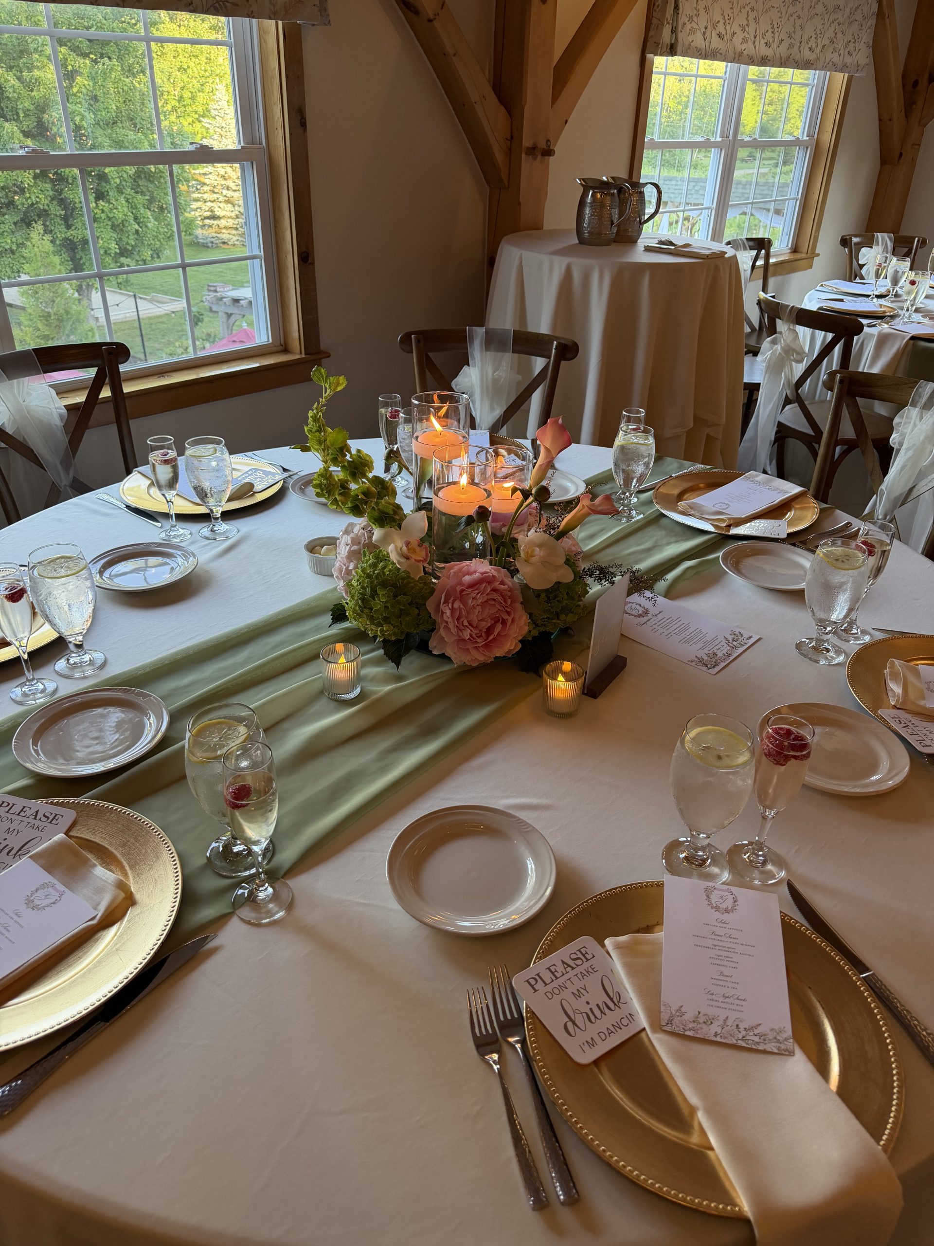 Sage green runners and gold chargers at a vineyard pavilion wedding at Zorvino Vineyards